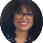 Headshot of black woman with large cat-eye eyeglasses, shoulder-length curly brown hair and black blouse.